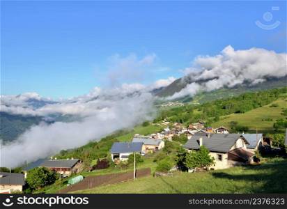 view on alpine village in a hill under cloudy sky in europe. view on alpine village in a hill under cloudy sky
