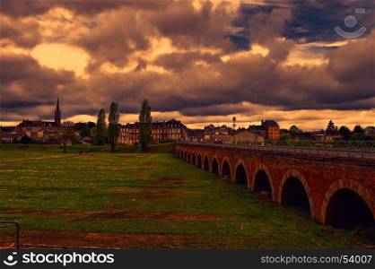 View on old houses and bridge in city of Sedan. France in rainy day at sunset