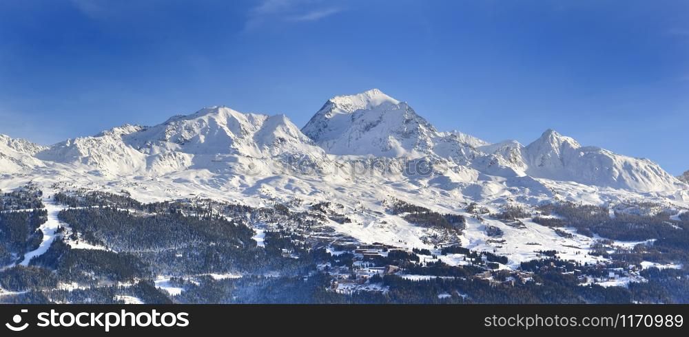 view on peak mountain covered with snow in winter above ski resort in european alps