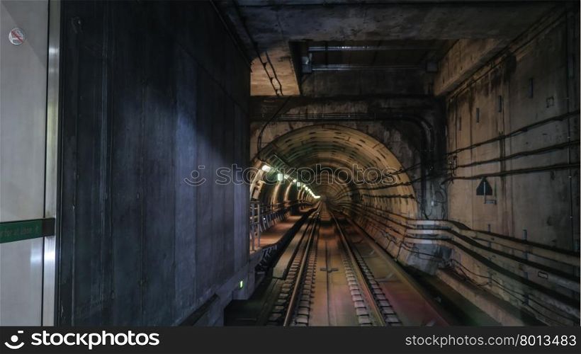 View on rails in metropolitan tube in lamps light. Metropolitan tube in lamps light