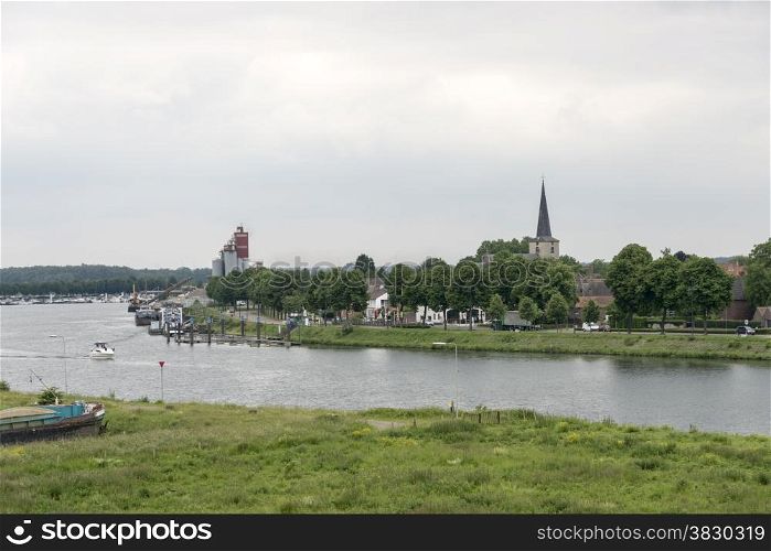 view on the dutch city skyline of wessem at the river maas