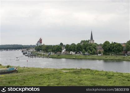 view on the dutch city skyline of wessem at the river maas