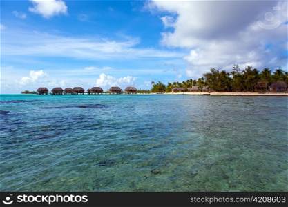 View on tropical island and small houses on the sea. Polynesia