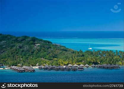 View over beautiful turquoise lagoon of bungalows, island and boats. Bora Bora Island, Tahiti, Society Islands, French Polynesia.. Travel and Stock Photography