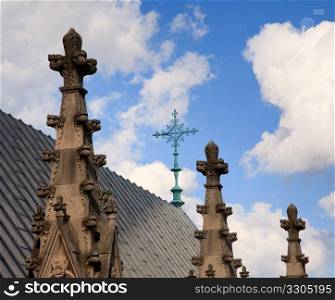 View over roof of cathedral towards wrought iron cross