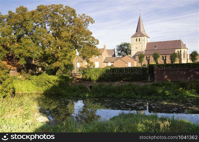 View over the Uffelse brook at Grathem church in the Dutch province Limburg. View at Grathem church