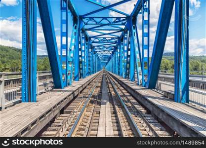 View through blue railway bridge across the river, industrial landscape