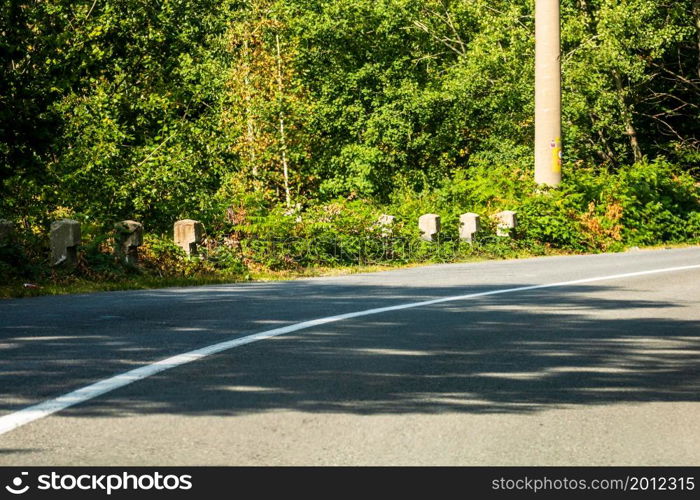 View through car windshield of mountain road between the trees on sunny day.. View through car windshield of mountain road between the trees on sunny day.