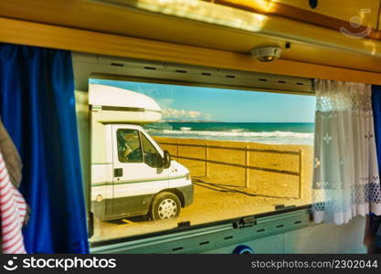 View through caravan window on camper camping on beach. Adventure with motor home.. View from caravan inside on camper on beach