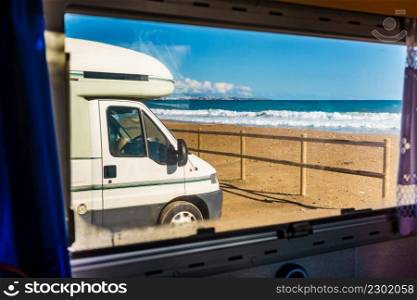View through caravan window on camper camping on beach. Adventure with motor home.. View from caravan inside on camper on beach