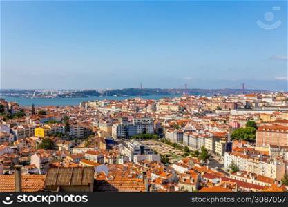 View to downtown of Lisbon with miltiple streets and houses and bridge of 25 of April over Tagys river, Portugal