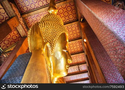 View to large golden statue of Reclining Buddha in temple Wat Pho. Bangkok, Thailand