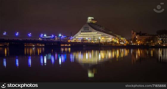 View to the National Library of Latvia next to the bridge in the evening with beautiful reflections in Daugava river