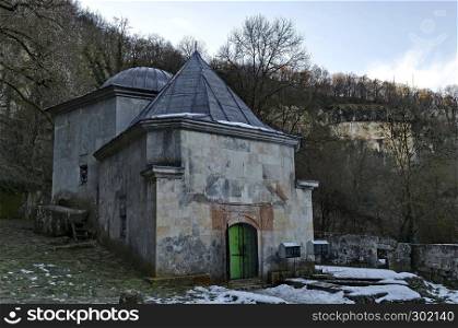 View toward temple with tomb, foundation of ancient building and stone door toward cliff in Demir Baba Teke, cult monument honored by both Christians and Muslims in winter near Sveshtari village, Municipality Isperih, Razgrad District, Northeastern Bulgaria