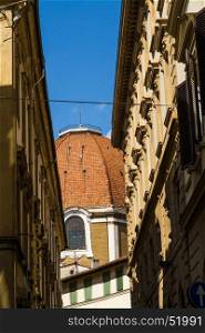 View up of a Florence street with terracotta cupola at end. Florence, Italy, Europe.