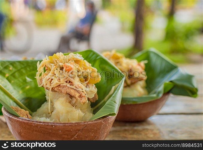 Vigoron with leaves served on a wooden table, two vigorones served on wooden background, vigoron typical food from nicaragua