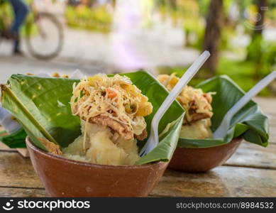 Vigoron with leaves served on a wooden table, two vigorones served on wooden background, vigoron typical food from nicaragua