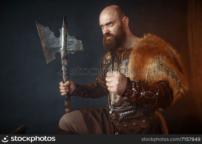 Viking with axe, martial spirit, barbarian image, side view. Ancient warrior in smoke. Viking with axe, barbarian, side view