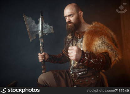 Viking with axe, martial spirit, barbarian image, side view. Ancient warrior in smoke. Viking with axe, barbarian, side view