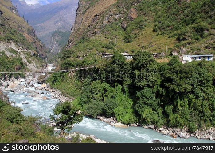 Village and suspension bridge near village in Nepal