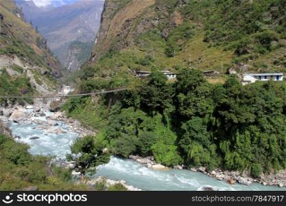 Village and suspension bridge near village in Nepal