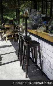 Village cafe with metal counter bar chairs, stock photo