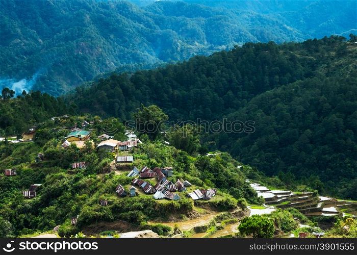 Village houses near rice terraces fields. Amazing abstract texture with sky colorful reflection in water. Ifugao province. Banaue, Philippines UNESCO heritage