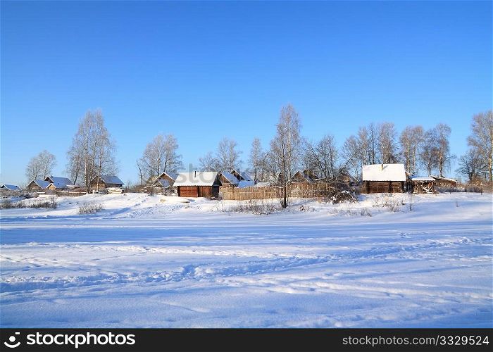 village in snow on coast river