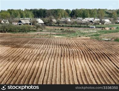 Village in the spring, the house and plowed field