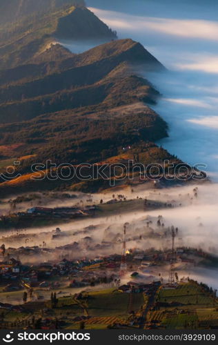 Village next to volcano Bromo, covered in fog