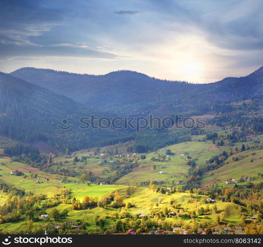 Village on bright green meadows in the mountains. Village on bright green meadows