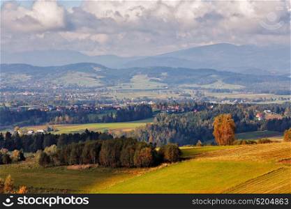Village on hills of tatra mountain range. Town in the middle of green fields