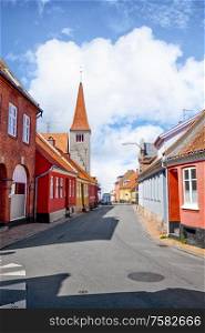 Village with a church in Denmark under a blue sky in the summer