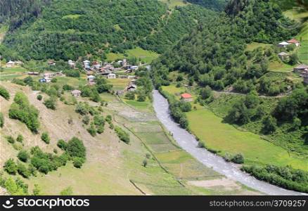 Village with old towers and mountain river. Svanetia