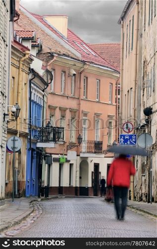 Vilnius oldtown street in a rainy day. Two people - motion blur