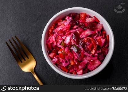 Vinaigrette, ?raditional ukrainian beetroot salad with boiled vegetables, pickled cucumbers, sour cabbage, olive oil and green canned peas. Vegetarian healthy dinner. Traditional ukrainian beetroot salad vinaigrette on a white plate on a black concrete or slate background