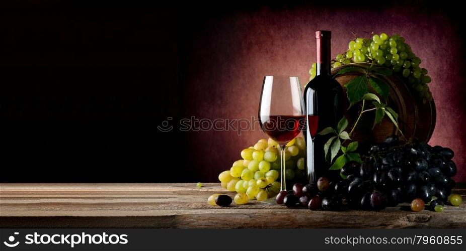 Vine of grape with wine on wooden table