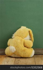 vintage abandoned toy bunny on a wooden floor