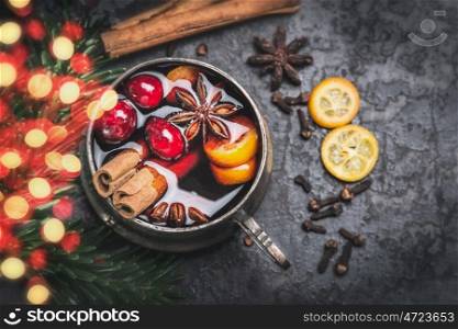 Vintage aged Cup of mulled wine with spices and bokeh lighting on dark vintage background, top view, close up