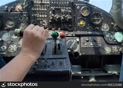 Vintage airplane dashboard with hand pushing leverer, shallow focus on hand. Vintage airplane dashboard