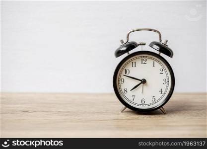 Vintage alarm clock on wooden table and copy space for text. Activity, daily routine, morning, workout and Work life balance concept