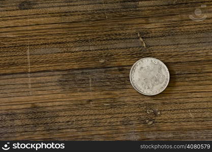 vintage American silver dollar lying on an oak board