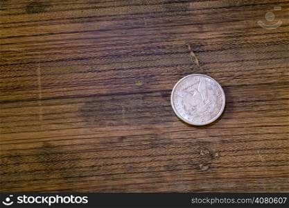 vintage American silver dollar lying on an oak board