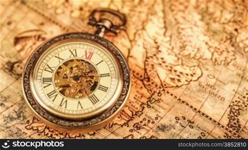 Vintage Antique pocket watch on ancient world map in 1565.