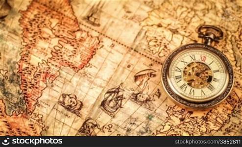 Vintage Antique pocket watch on ancient world map in 1565.