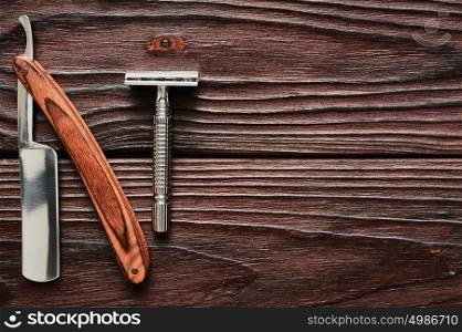 Vintage barber shop razor tools on old wooden background