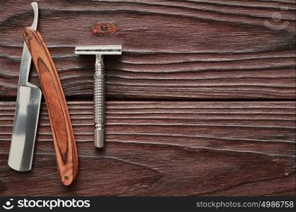 Vintage barber shop razor tools on old wooden background