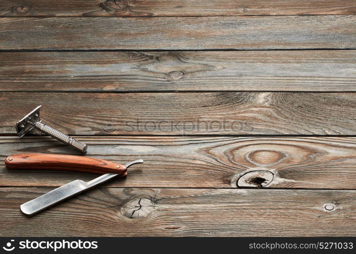 Vintage barber shop razor tools on old wooden background