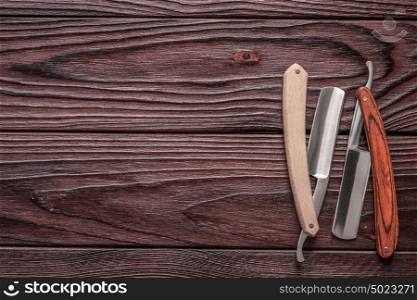 Vintage barber shop straight razor tool on old wooden background
