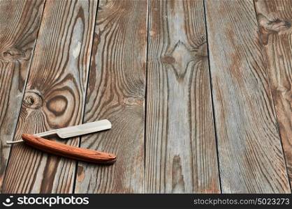 Vintage barber shop straight razor tool on old wooden background